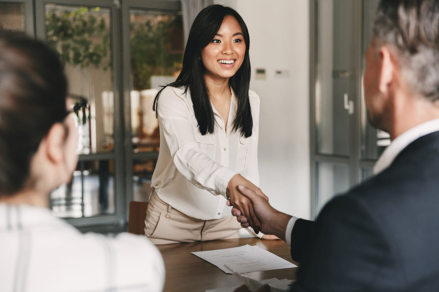 Woman shaking hands with a man in an office setting